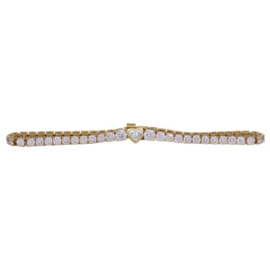 yellow gold tennis bracelet set with round brilliant diamonds and one bezel set heart diamond