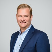 A smiling man wearing sunglasses and a red cap, holding a large cup.