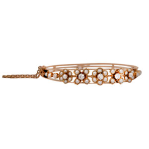 Antique 14k yellow gold flower bangle bracelet set with 0.66 carats of old European cut earth-mined diamonds and seed pearls.