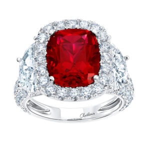 New 18k white gold Chatham halo ring set with a 4.91 carat oval lab-grown ruby plus 2.60 carats of round brilliant and trillion cut lab-grown diamonds.