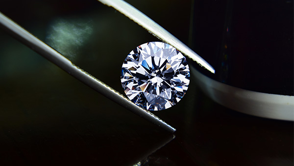 an image of a lab-grown diamond being help by tweezers
