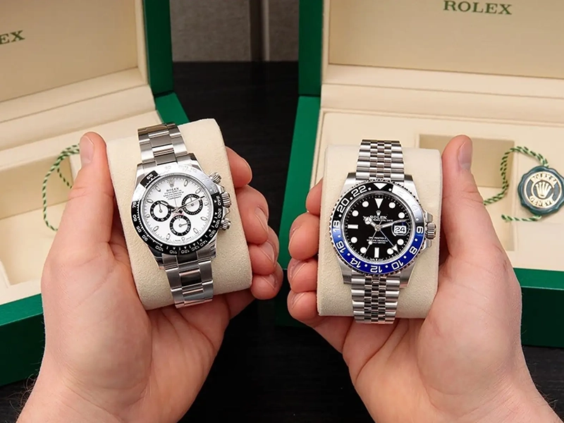 a close up image of someone holding two rolexs in their hands