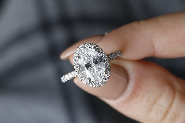 a close up image of a woman holding a diamond engagement ring