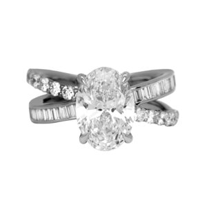New 14k white gold engagement ring set with a 3.00 carat lab-grown oval diamond plus 0.90 carats of lab-grown round brilliant and baguette diamonds.