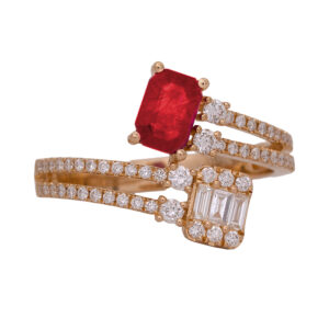 New 14k yellow gold bypass ring set with a 0.82 carat emerald cut ruby plus 0.46 carats of round brilliant and baguette earth-mined diamonds.