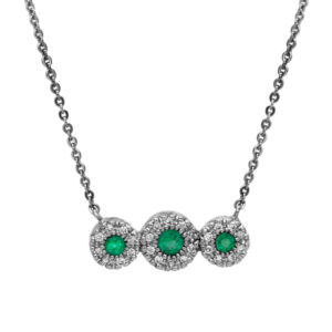 New 14k white gold three stone halo pendant set with 0.25 carats of round brilliant emeralds and 0.11 carats of round brilliant earth-mined diamonds on a 16" cable chain.
