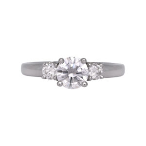 Vintage platinum three stone engagement ring set with a 0.95 carat round brilliant earth-mined diamond plus 0.25 carats of round brilliant earth-mined diamonds.