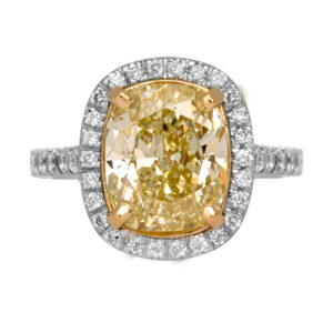 Vintage 18k white and yellow gold halo ring set with a 5.05 carat cushion fancy yellow earth-mined diamond plus 1.00 carat of round brilliant earth-mined diamonds.