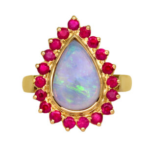 Vintage 14k yellow gold halo ring set with a 1.50 carat pear opal plus 1.20 carats of round brilliant rubies.