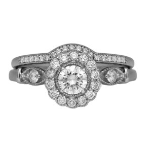 Vintage 14k white gold halo engagement ring and wedding band set with a 0.50 carat round brilliant earth-mined diamond plus 0.41 carats of round brilliant earth-mined diamonds.